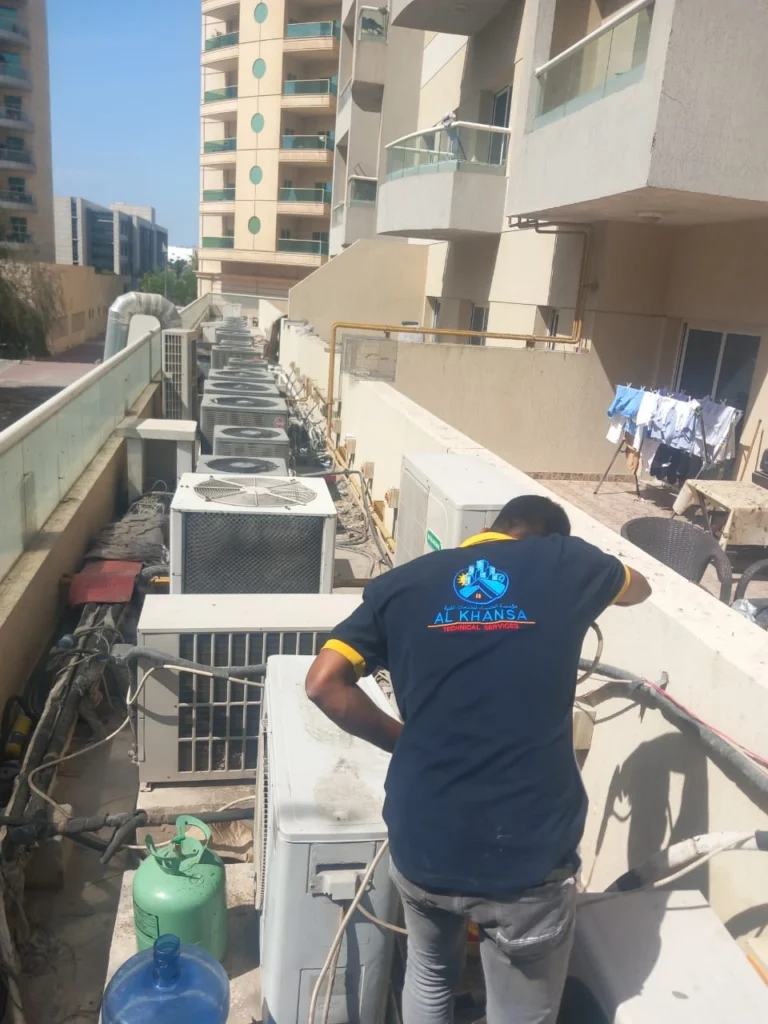 worker repairing AC in ajman